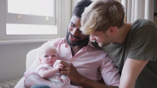 Amando Casal Masculino Mesmo Sexo Abraçando Filha Bebê Sofá Casa — Vídeo de Stock