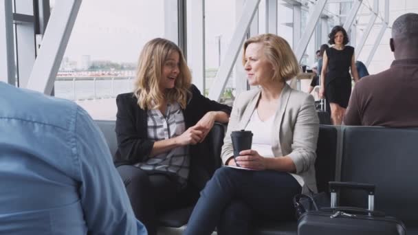 Two Businesswomen Sitting Airport Departure Lounge Flight Talking Together Shot — Stockvideo