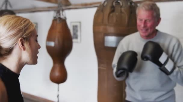 Senior Boxer Mladší Trenérkou Tělocvičně Pomocí Tréninkových Rukavic Zastřelen Zpomaleném — Stock video