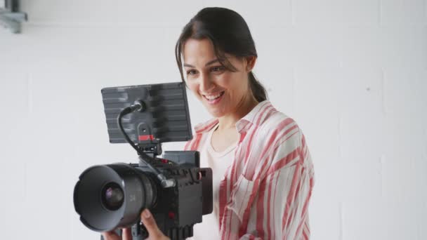 プロの女性撮影監督は ビデオを撮影し スタジオでカメラモデルをオフに方向性を与える スローモーションで撮影 — ストック動画