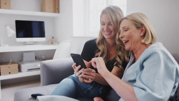 Senior Mother Adult Daughter Sitting Sofa Home Looking Photos Mobile — Stock Video