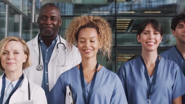 カメラは 現代の病院の建物に立っている男性と女性の医療チームの顔全体を追跡します スローモーションで撮影 — ストック動画