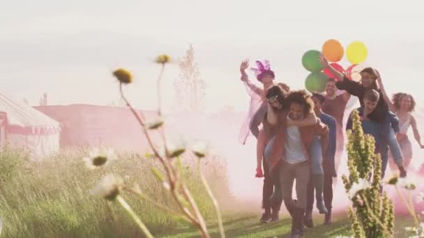 一群年轻的朋友带着气球和烟花在音乐节现场漫步 慢镜头拍摄 — 图库视频影像