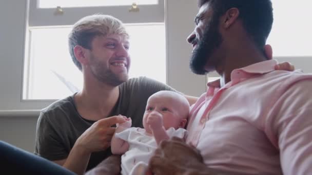 Amando Casal Mesmo Sexo Masculino Abraçando Filha Bebê Sofá Casa — Vídeo de Stock