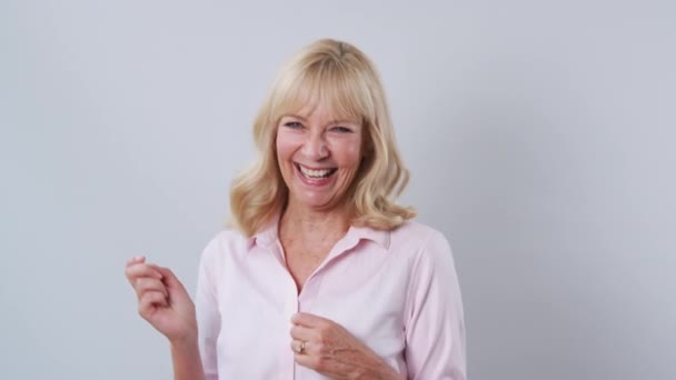 Studio Shot Van Volwassen Vrouw Tegen Witte Achtergrond Lachen Dansen — Stockvideo