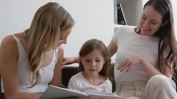 Gleichgeschlechtliches Paar Liest Buch Mit Tochter Hause Zeitlupe Gedreht — Stockvideo