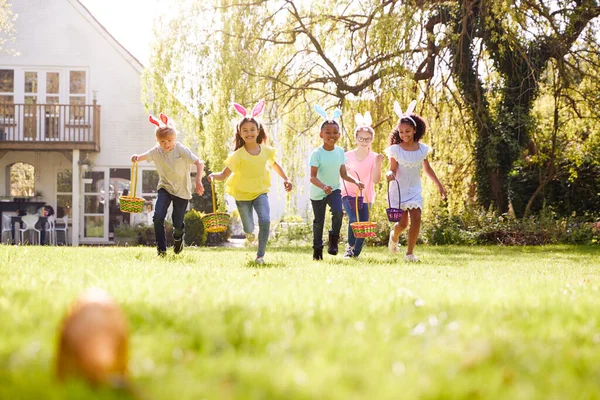 Kindergruppe Mit Hasenohren Rennt Zur Ostereiersuche Garten — Stockfoto