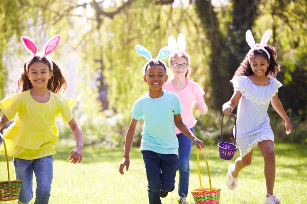 Kindergruppe Mit Hasenohren Rennt Zur Ostereiersuche Garten — Stockfoto