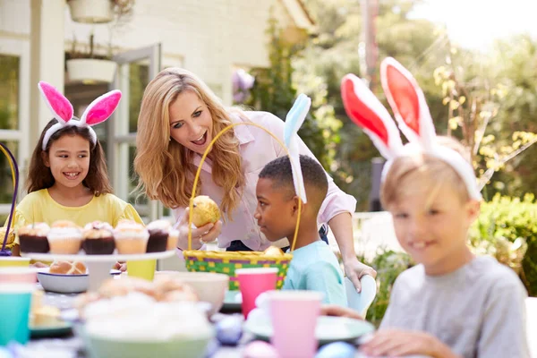 バニーの耳を身に着けている子供たちと一緒に自宅で庭で屋外イースターパーティーを楽しむ — ストック写真