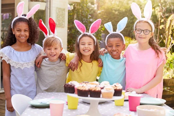 穿着兔子耳朵的孩子在自家花园享受户外复活节派对的肖像 — 图库照片