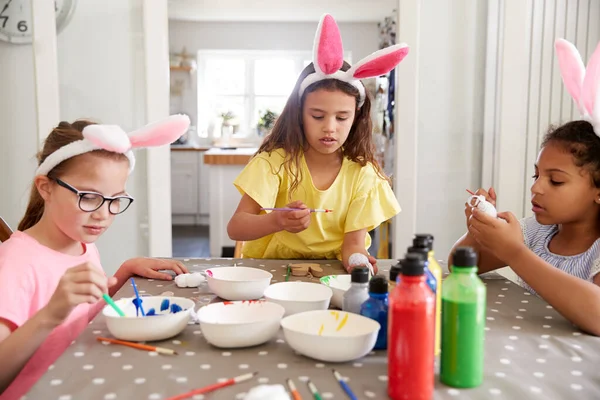 Drei Mädchen Mit Hasenohren Sitzen Tisch Und Dekorieren Eier Für — Stockfoto