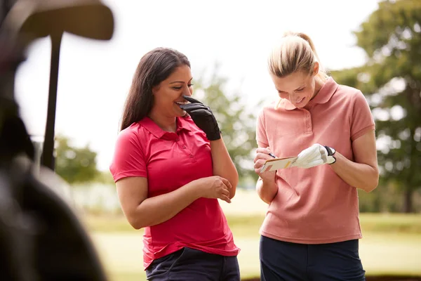 Dvě Ženy Hraje Golf Značkování Záznam Buggy Popředí — Stock fotografie