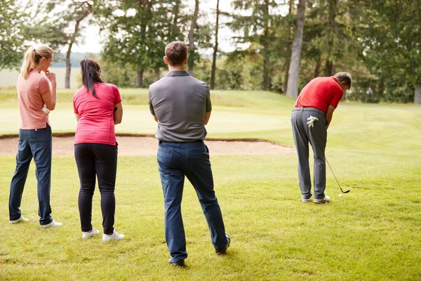 レッスン中にゴルファーのグループにフェアウェイでショットを示すゴルフ専門家 — ストック写真