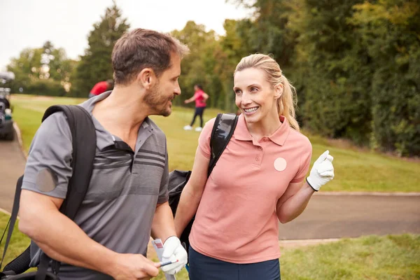 熟女カップルゴルフバッグを運ぶと話してゴルフのラウンドを再生 — ストック写真