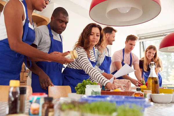 Männliche Und Weibliche Erwachsene Studenten Betrachten Rezept Kochkurs Der Küche — Stockfoto