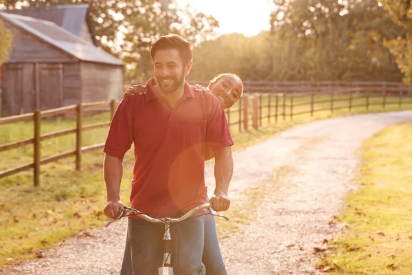 日落时分 浪漫的情侣们骑着自行车沿着乡间小路 — 图库照片
