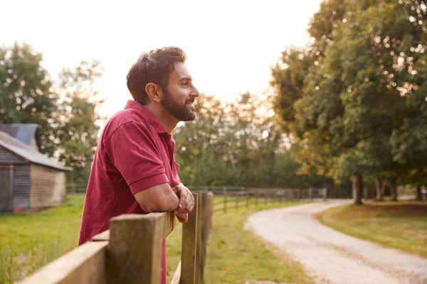 Glimlachende Man Neemt Een Pauze Rust Hekken Tijdens Een Wandeling — Stockfoto