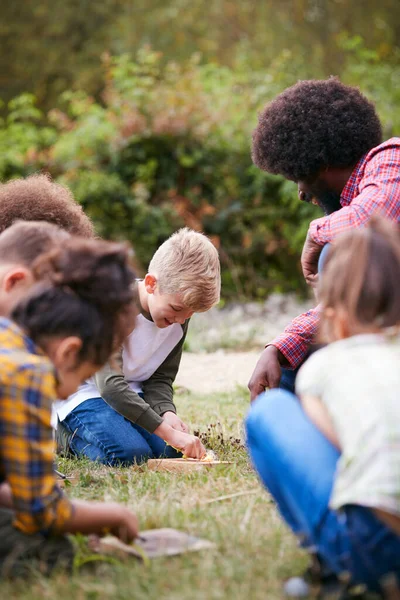 Teamleiter Zeigt Kindergruppe Auf Outdoor Campingausflug Wie Man Feuer Macht — Stockfoto