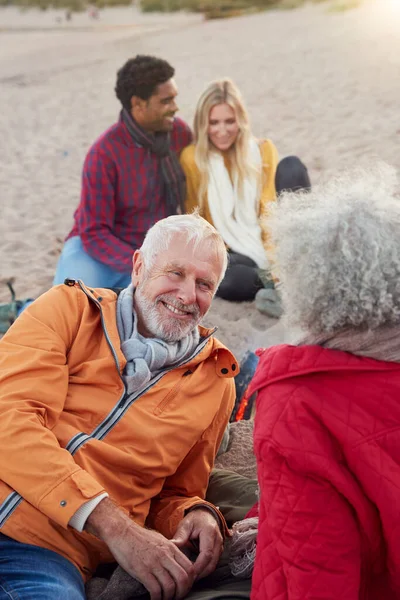 Liebendes Senior Paar Entspannt Feuer Mit Erwachsenem Nachwuchs Winter Strandurlaub — Stockfoto