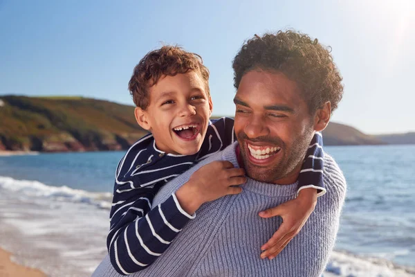 爱的父亲在儿子与儿子一起走过冬季海滩时给予他们回音 — 图库照片