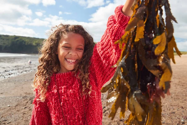 Portrait Smiling Girl Holding Seaweed Winter Beach Vacation — Foto de Stock