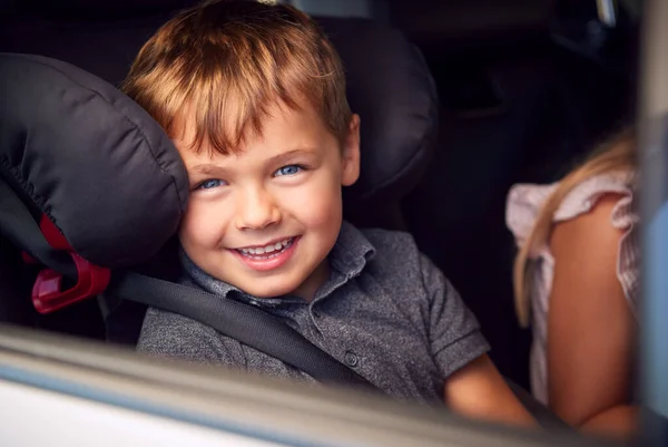 車の旅で子供の安全シートに座っている若い男の子の肖像画窓の外を見る — ストック写真