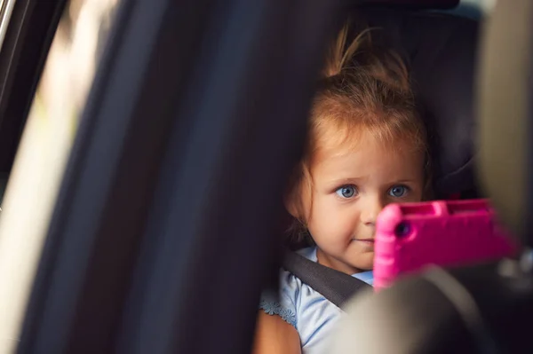 若い女の子は車の旅で後部座席でデジタルタブレットを見て — ストック写真