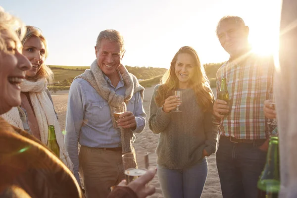 冬のビーチ休暇でワインを祝う世代の大人の家族 — ストック写真