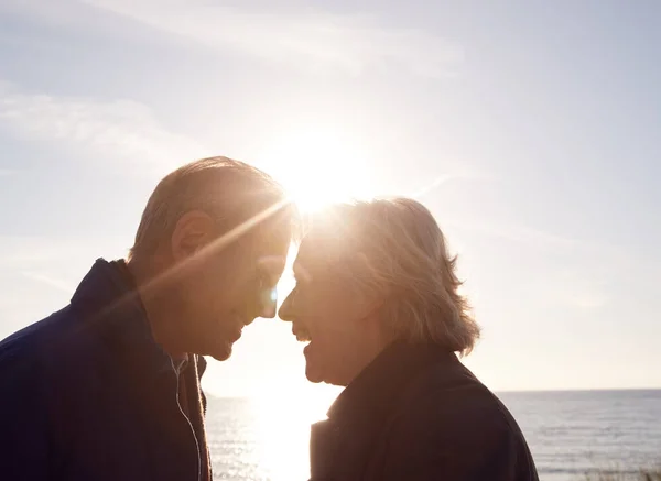 輝く太陽の下で砂丘を歩きながら手を取り合う現役シニアカップルを愛する — ストック写真