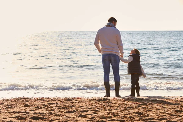 Bakifrån Far Med Son Tittar Till Havs Silhouetted Mot Solen — Stockfoto