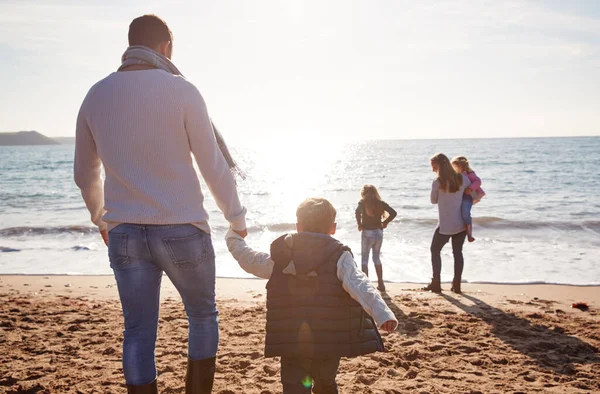 太陽に対してシルエット海に向かって歩く家族の風景 — ストック写真