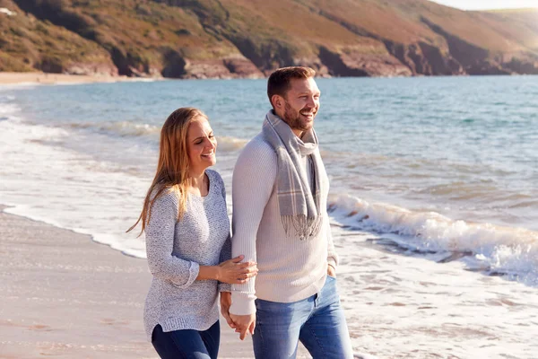 情侣们手牵手沿着海滨浪花的海岸线漫步时的爱 — 图库照片