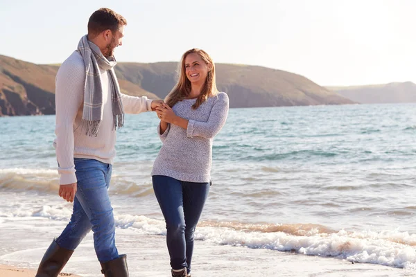 情侣们手牵手沿着海滨浪花的海岸线漫步时的爱 — 图库照片