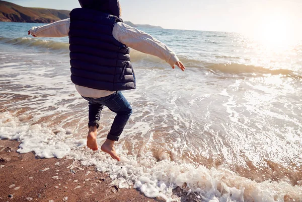 Zbliżenie Młody Chłopiec Mając Zabawy Przeskakując Fale Plaży — Zdjęcie stockowe