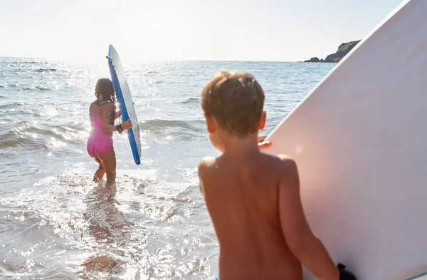 暑期海滩度假时与体板在海里玩耍的儿童 — 图库照片