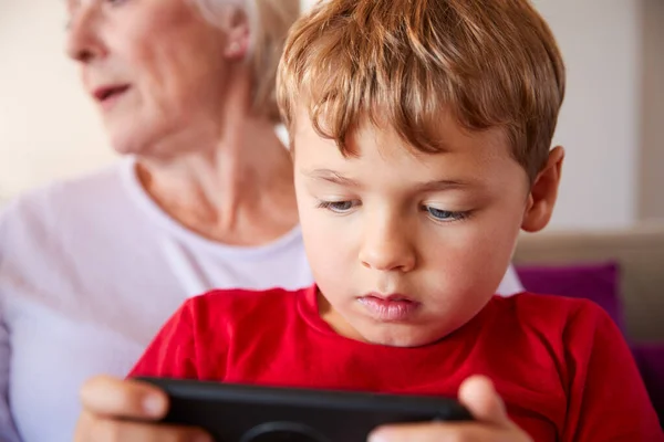 Mormor Spelar Spel Med Sonson Mobiltelefon Hemma — Stockfoto