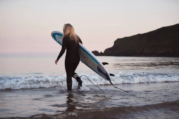 Mujer Vistiendo Traje Neopreno Llevando Tabla Surf Mientras Camina Mar — Foto de Stock