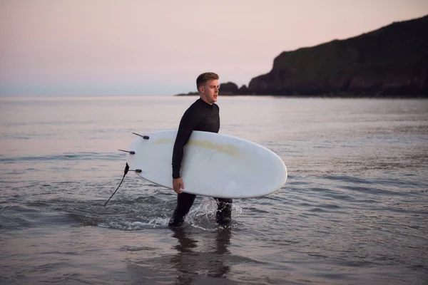 Hombre Con Traje Neopreno Llevando Tabla Surf Mientras Camina Fuera — Foto de Stock