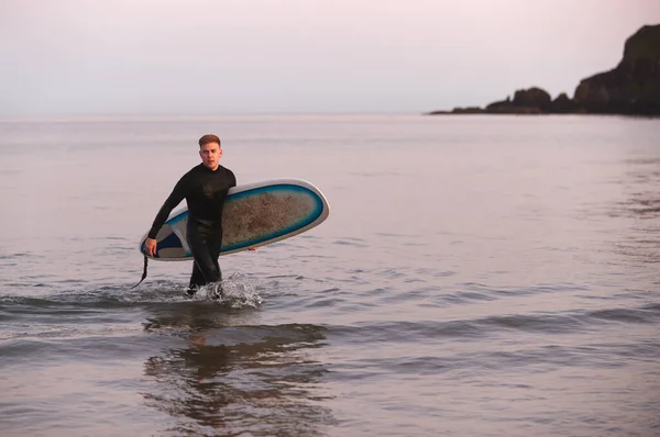 Hombre Con Traje Neopreno Llevando Tabla Surf Mientras Camina Fuera — Foto de Stock