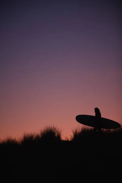Silhouet Van Vrouwelijke Surfer Die Surfplank Draagt Duinen Tegen Ondergaande — Stockfoto