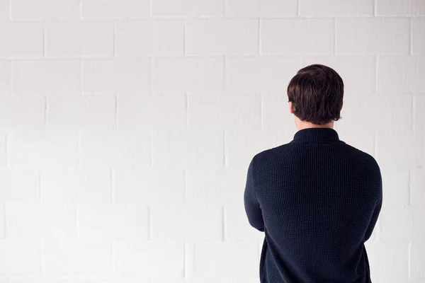 Beyaz Stüdyo Duvarına Karşı Duran Gelişigüzel Giyinen Adam Arka Görünümü — Stok fotoğraf