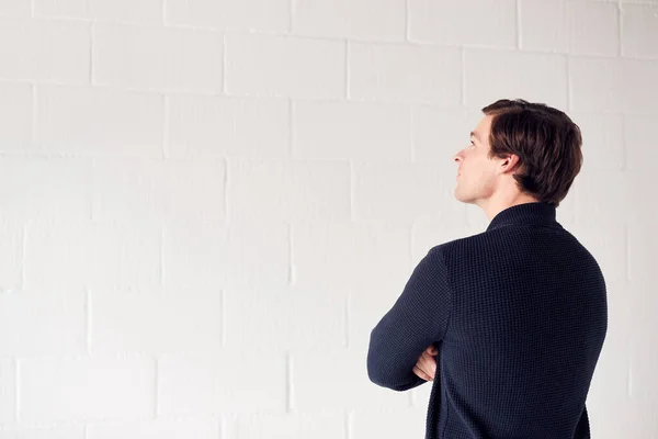 Achteraanzicht Van Casual Geklede Man Staande Tegen Witte Studio Wall — Stockfoto