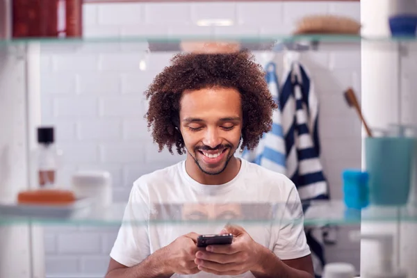 Utsikt Genom Badrummet Skåp Man Kontrollera Meddelanden Telefon Innan Går — Stockfoto