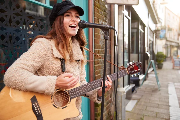 女性ミュージシャンブッキングストリートでアコースティックギターを演奏し 屋外で歌う — ストック写真