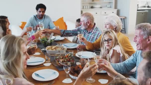 Familia Multigeneracional Haciendo Brindis Mientras Sientan Alrededor Mesa Para Comer — Vídeos de Stock