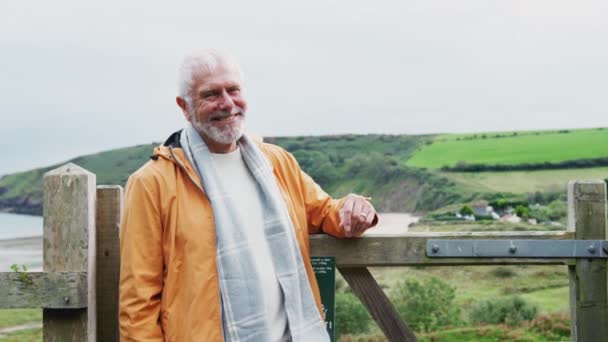 Sonbaharda Kıyı Yolunda Yürürken Kapıda Dinlenen Gülümseyen Yaşlı Adamın Portresi — Stok video