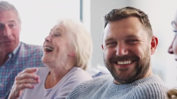 Pais Idosos Relaxando Com Filhos Adultos Sentados Sofá Casa Conversando — Vídeo de Stock