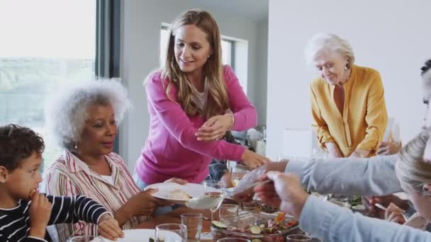 多世代の家族が一緒に家で食事のためにテーブルの周りに座っている スローモーションで撮影 — ストック動画