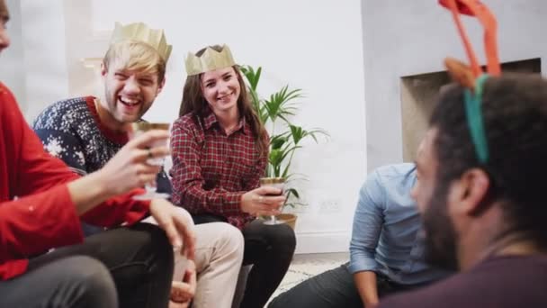 Группа Друзей Дома Сидящих Гостиной Наслаждаясь Шампанским Разговаривая После Рождественской — стоковое видео