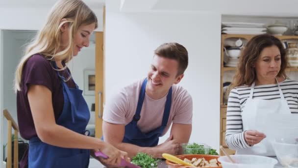 男男女女穿着围裙 在厨房烹调课上准备配菜 动作缓慢 — 图库视频影像
